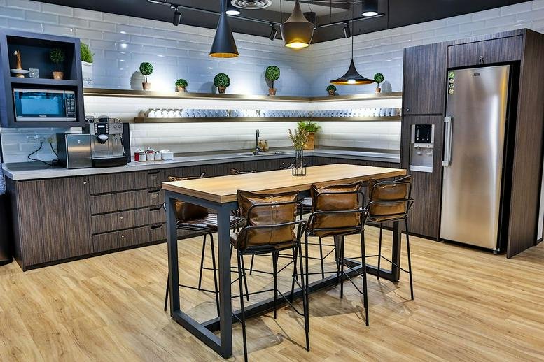 Modern kitchen and break area at Menara Standard Chartered with wood-top island and dark cabinetry.