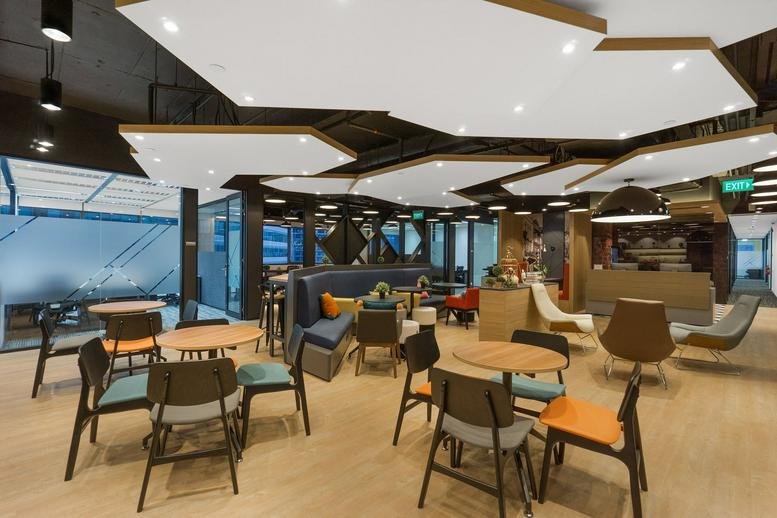 Spacious lounge at Menara Standard Chartered with diverse seating options and modern lighting fixtures.