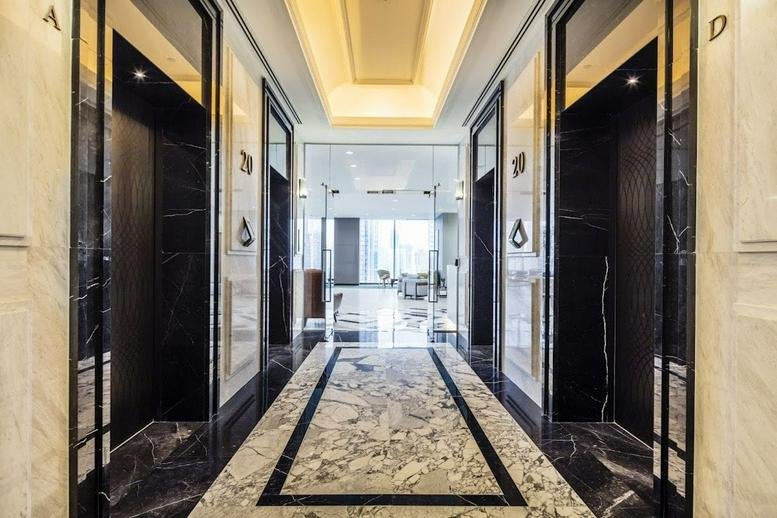 Elevator lobby with marble flooring and recessed lighting.
