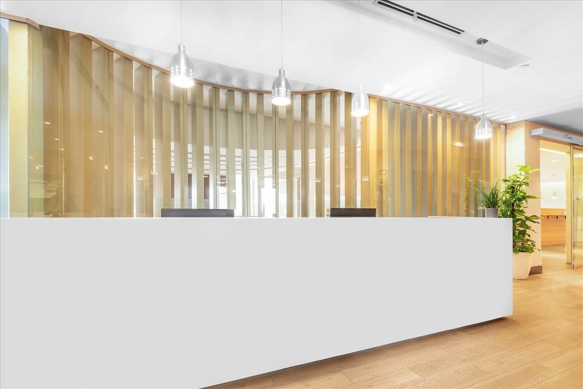 Modern reception desk at Moon tower with a decorative slatted wood backdrop.