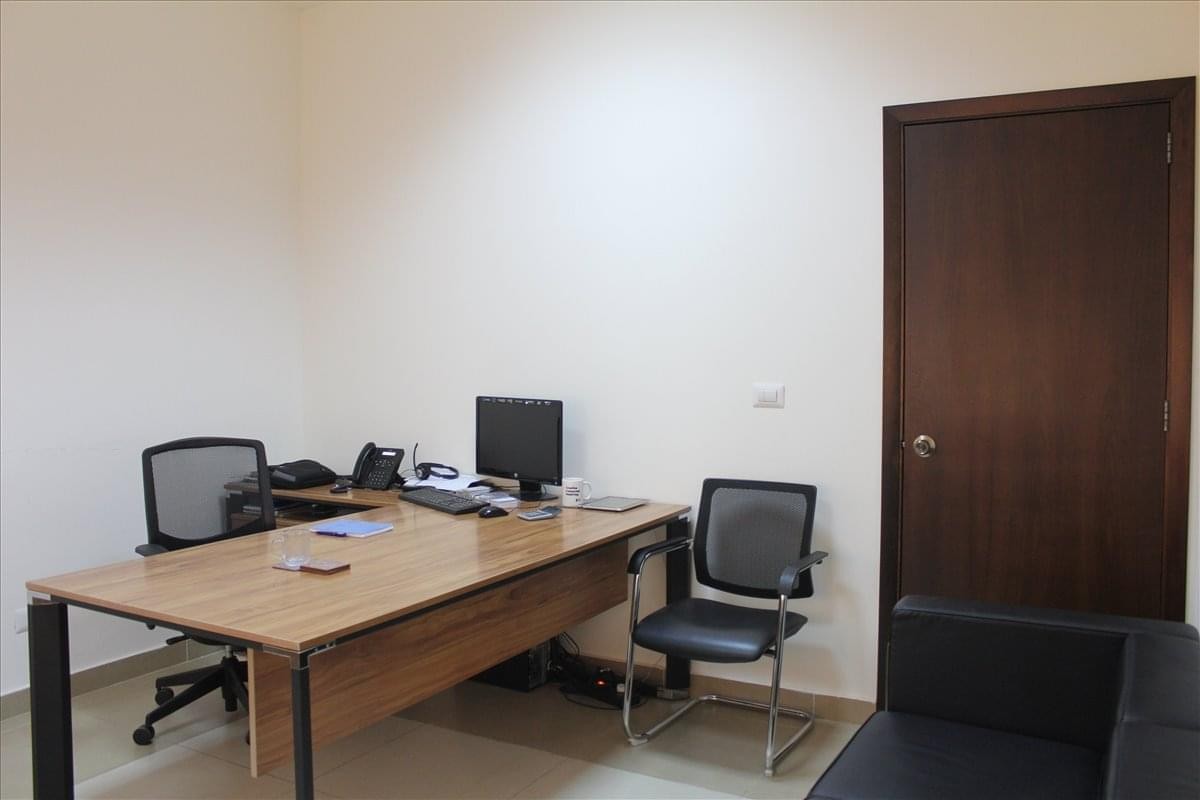 Private office at Museum str, Badaro 4916 bldg, with a wooden desk and two mesh chairs.