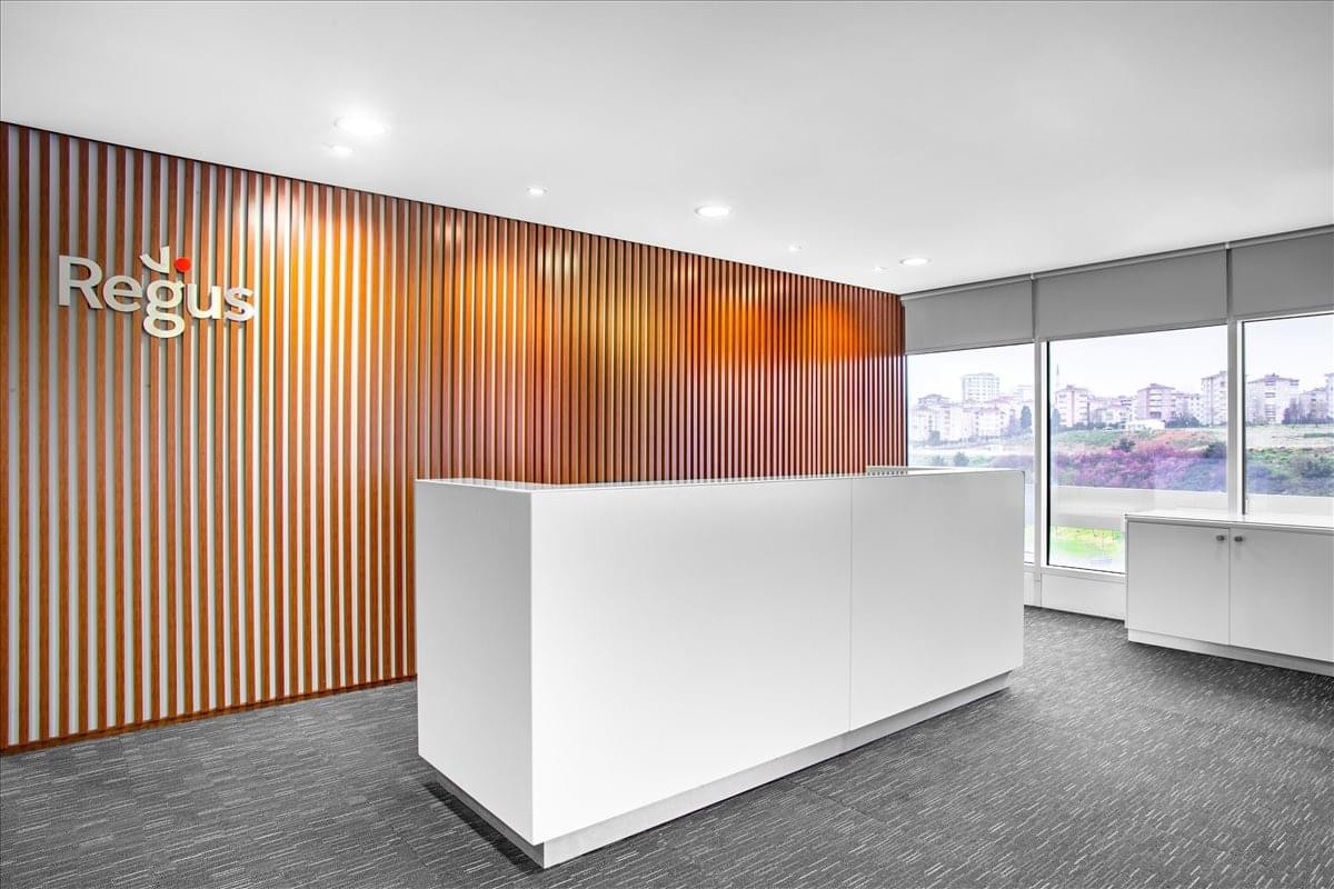 Professional reception area with a sleek white desk and a wood-slatted feature wall with branding.