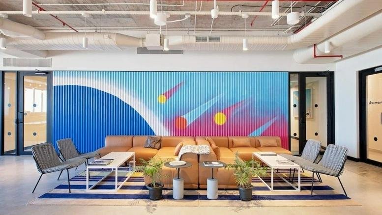 Spacious lounge at No. 78, Next to KR Puram Tin Factory with a colorful mural and leather sectional sofa.