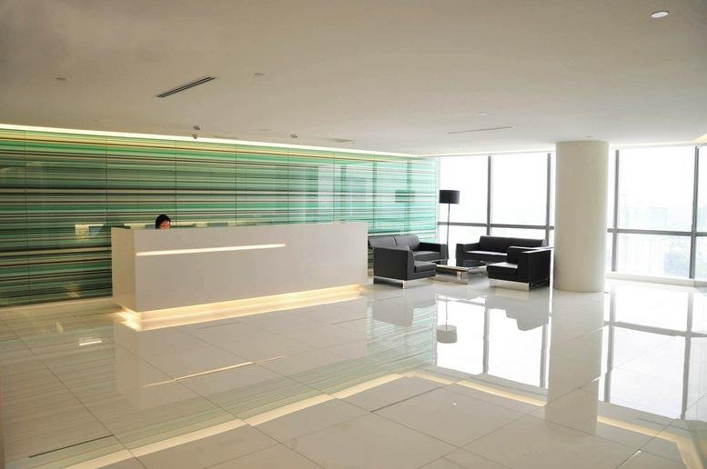 Modern reception area with a minimalist white desk and green striped feature wall.