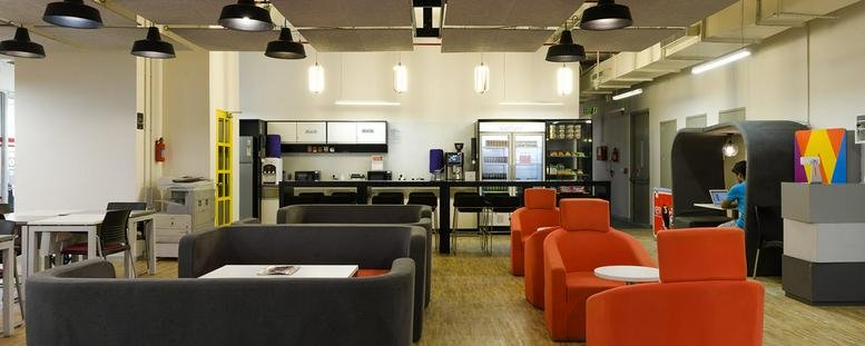 Spacious communal lounge and kitchen area at Nucleus Mall, 1 Church Road with orange armchairs and a breakfast bar.
