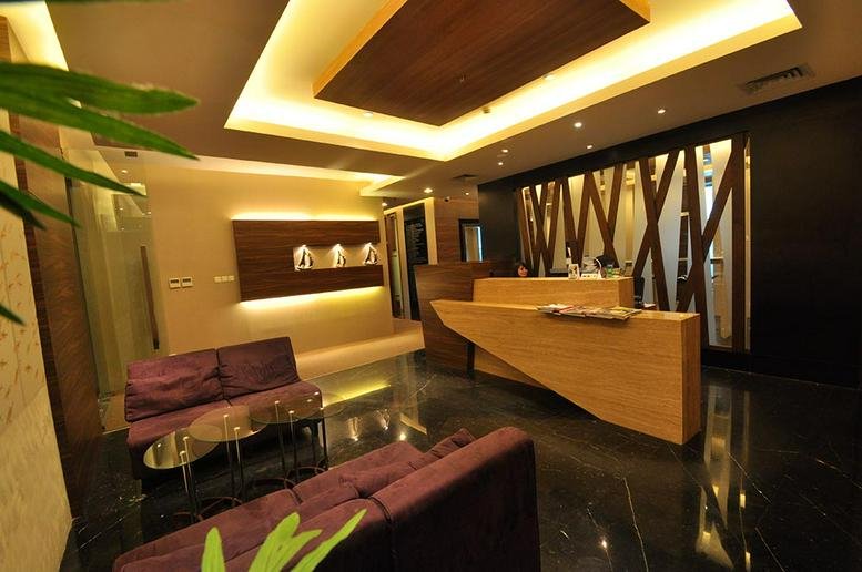 Modern lobby and reception area at OFFICE 8, Level 18-A with warm wood finishes and purple seating.