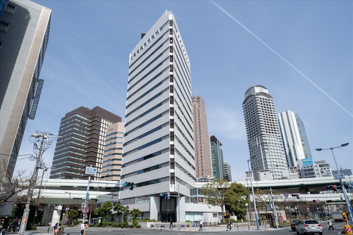 Exterior view of the white high-rise Pacific Marks Nishi-Umeda building against a blue sky.