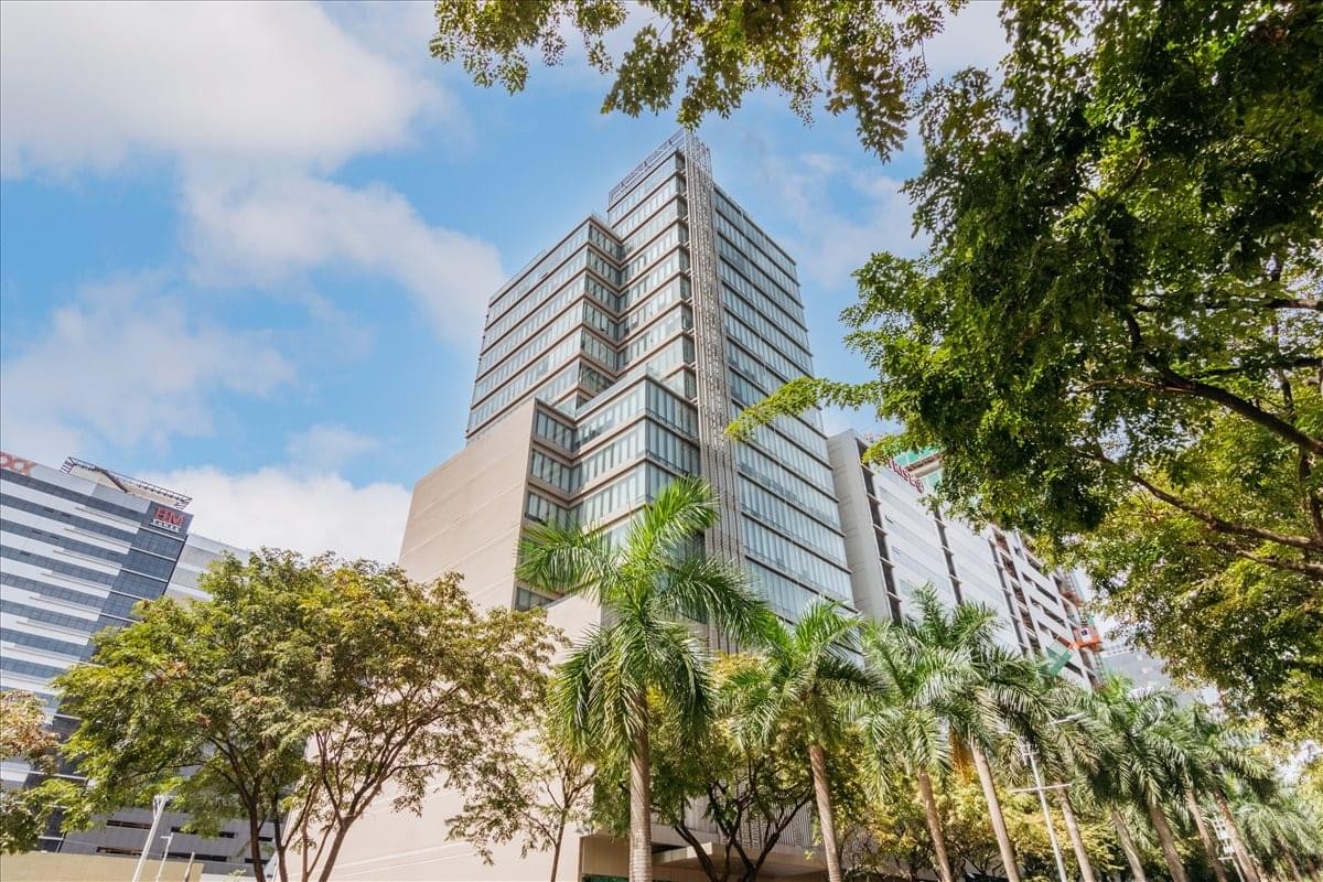 Low angle exterior view of the glass and concrete Park Centrale Building against a blue sky.