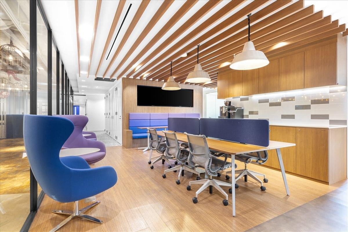Modern coworking space at Passenger Terminal 1, Haneda Airport with wood-slat ceilings and vibrant blue seating.