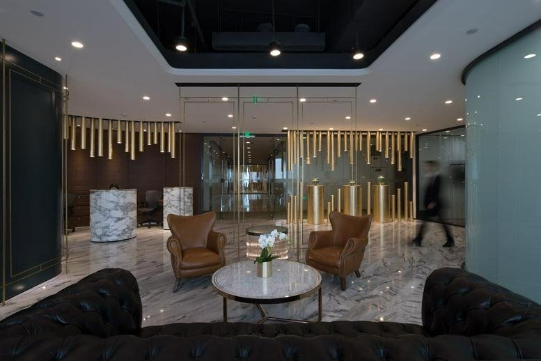 Elegant reception area featuring marble floors and plush brown leather armchairs.
