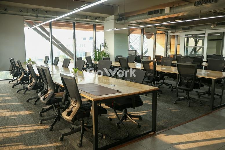 Spacious open-plan office at Plot No. 108, Udyog Vihar Phase 1 with wooden desks and ergonomic chairs.