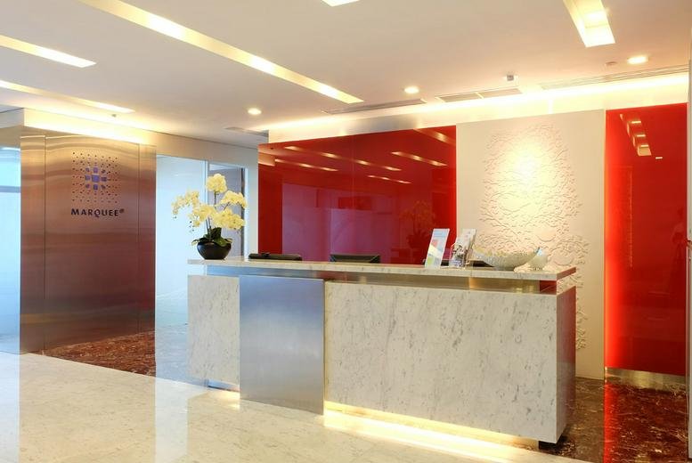 Modern reception area featuring a marble desk and vibrant red accent walls.