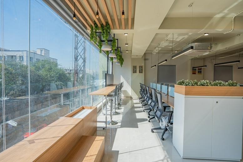 Spacious open-plan coworking area at Deskins, Puppalaguda, Manikonda, Hyderabad, India with city views.