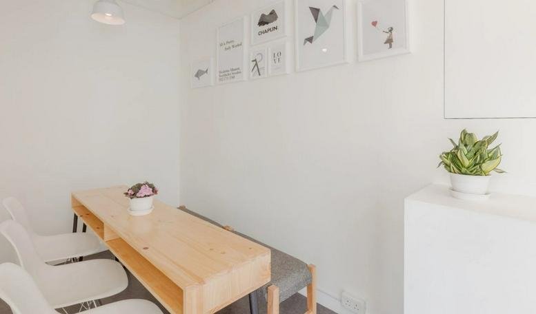 Bright communal dining area at Radio City, 15/F, 505 Hennessy Road with wooden table and framed wall art.