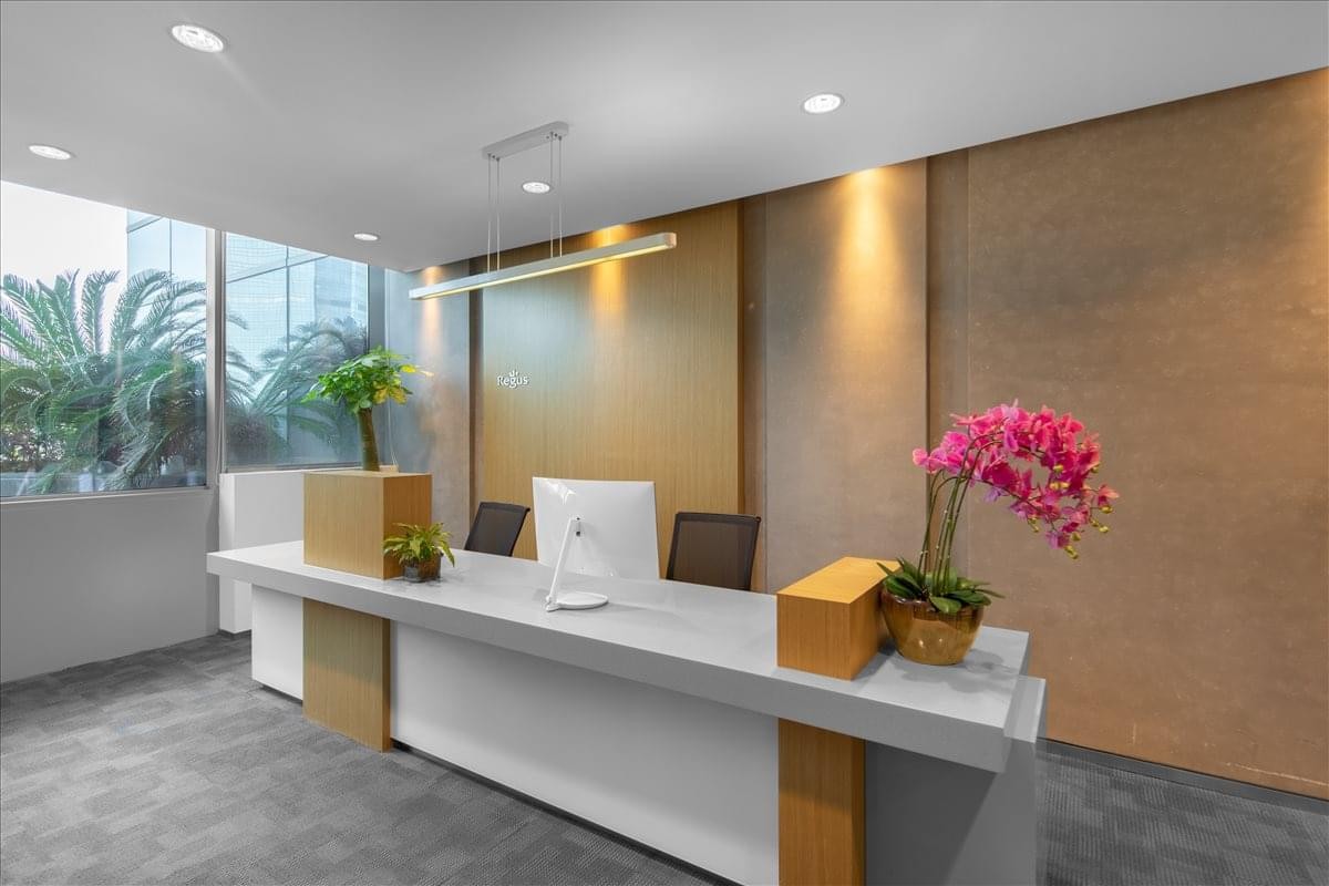 Professional reception desk at Raffles City, No. 99, South Daqing Road with warm wood accents and pink orchids.