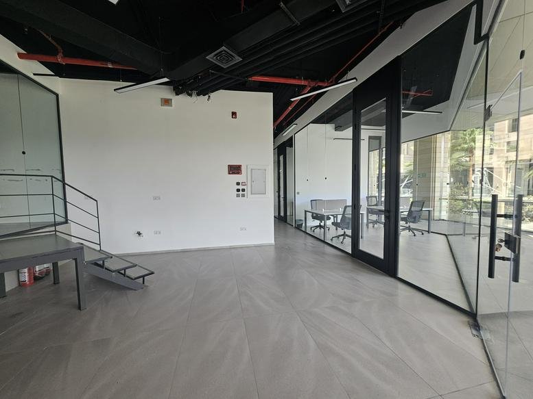 Spacious reception area with modern grey flooring and industrial ceiling design at V Business Center.