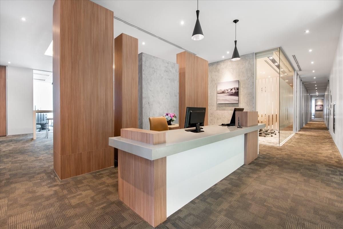 Reception desk at 89 AIA Capital Center featuring warm wood paneling and bright overhead lighting.