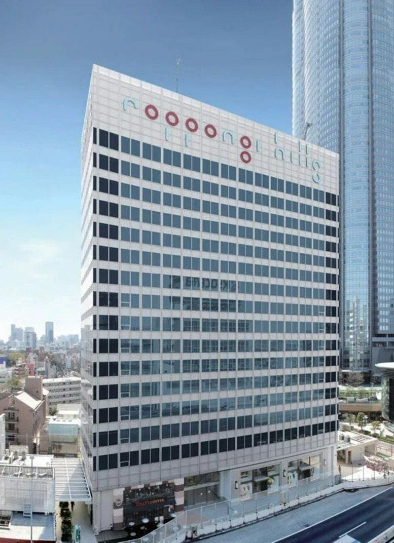 Exterior view of the white facade Roppongi Hills North Tower with red circle logos.