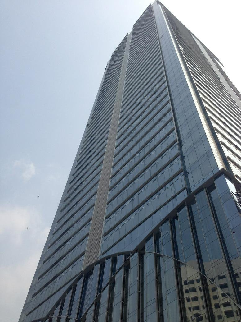 Exterior view of the Sahid Sudirman Center building against a blue sky.