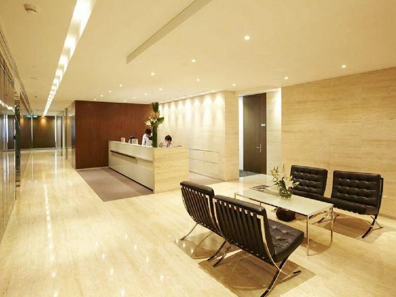 Spacious marble-floored lobby at Sampoerna Strategic Square with warm lighting and leather seating.