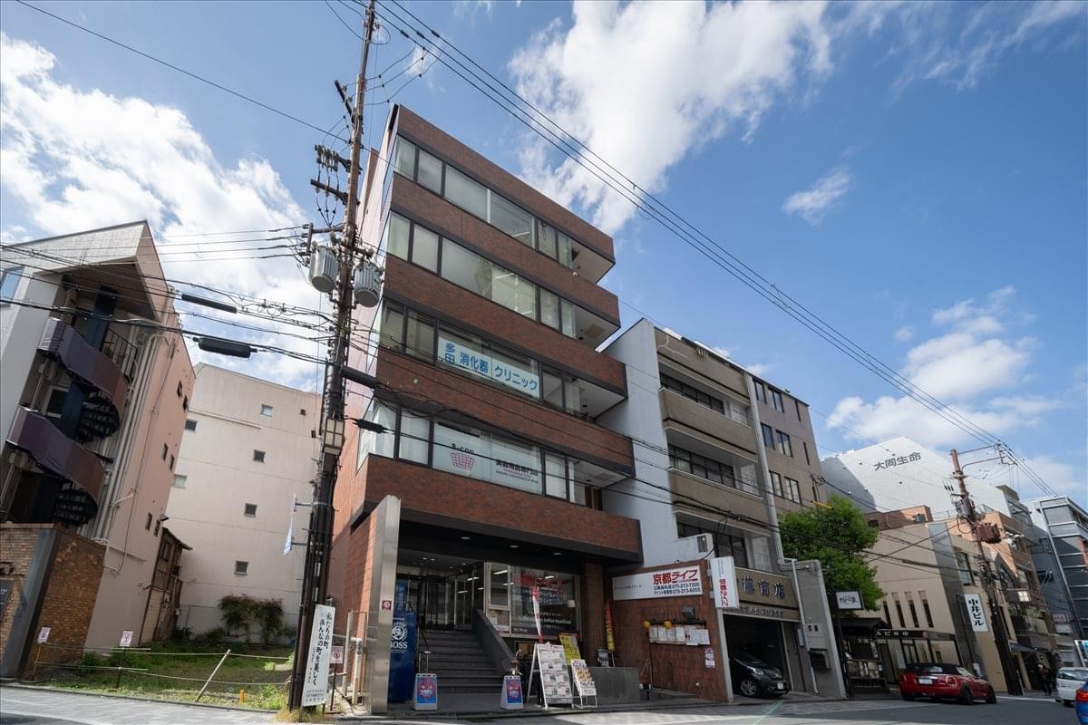Exterior view of the multi-story brown brick and glass 4F/5F Sanjo COHJU building.