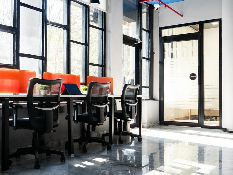 Bright open-plan workspace at Coworkio, 1st Floor, SCO 142-144, Sector 17C with orange dividers and ergonomic chairs.