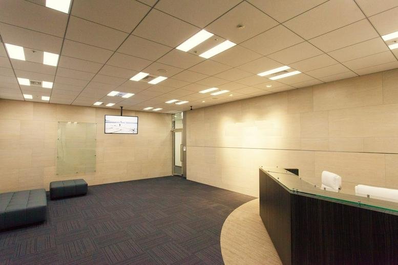 Spacious reception area with a dark wood desk and warm lighting at Sendai Trust Tower, 1-9-1 Ichibancho Aoba-ku.