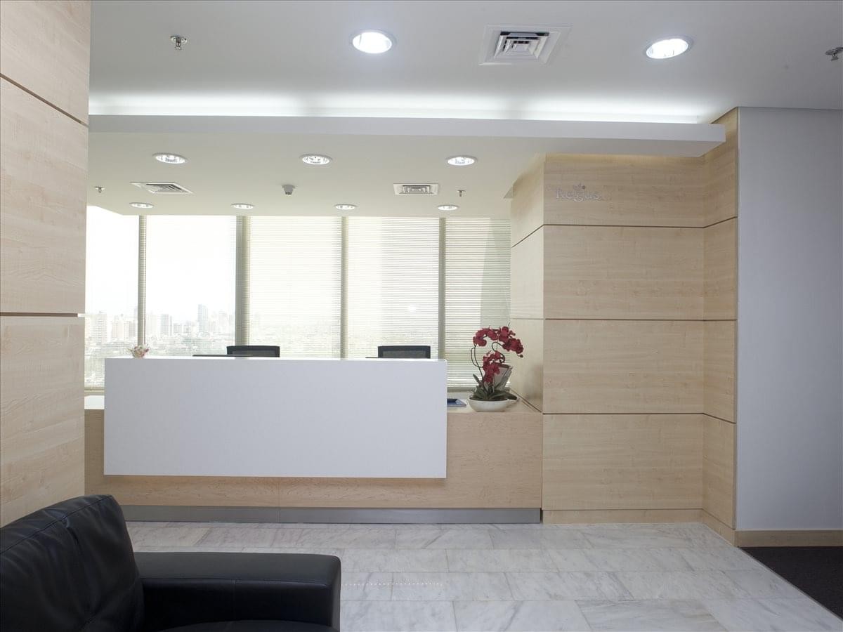 Modern reception area with a minimalist white desk and light wood paneled walls.