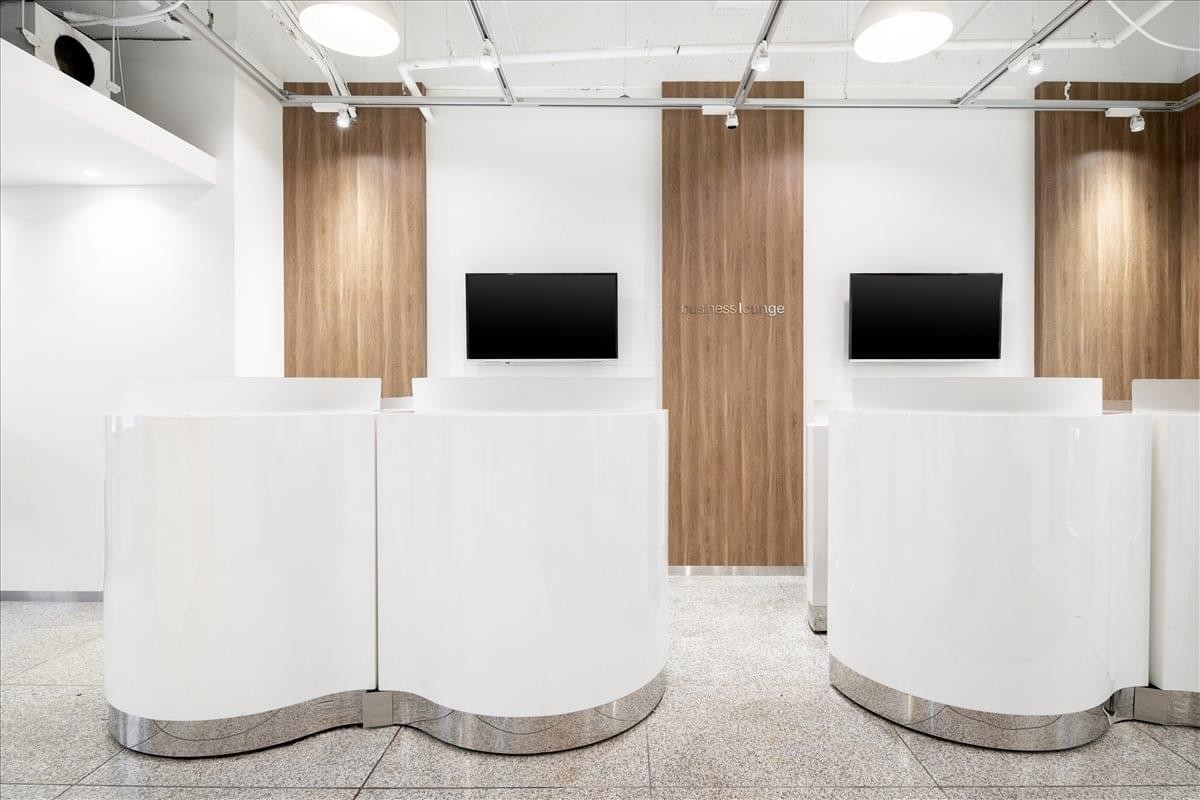 Modern white reception booths with wood paneling at Shinjuku Yamato Building.