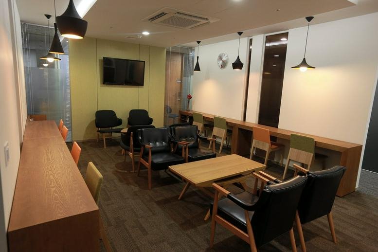 Spacious breakout area with various styles of seating and modern pendant lighting.