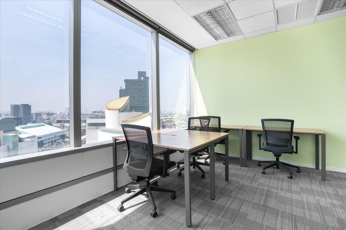 Private office at The Siam Tower featuring desks and floor-to-ceiling windows with city views.