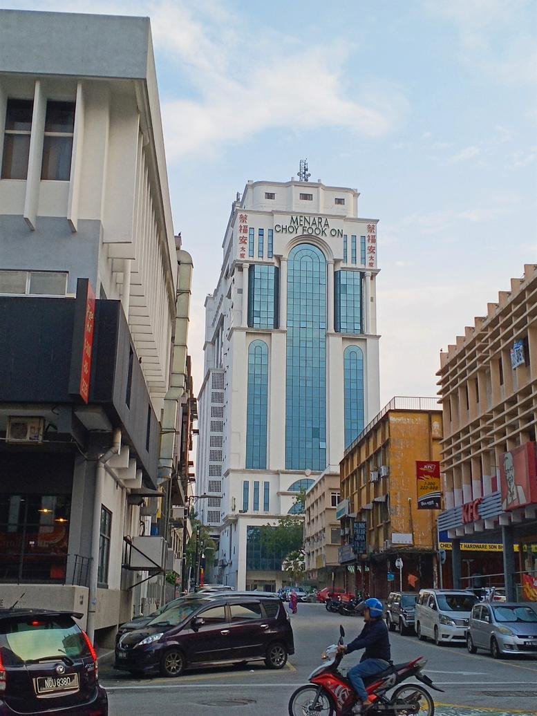 Street view of the high-rise Menara Choy Fook On building under a clear sky.