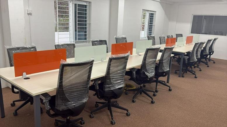 Spacious open-plan workspace with orange privacy dividers at Srinivasam, Vaiyapuri Nagar, Kurumbapalayam.