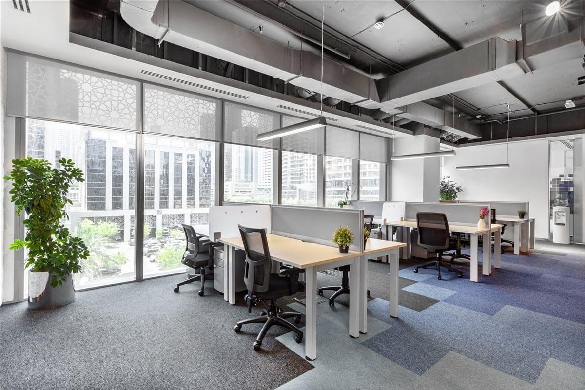 Open-plan workspace at Standard Chartered Tower, Emaar Square, featuring modern desks and city views.