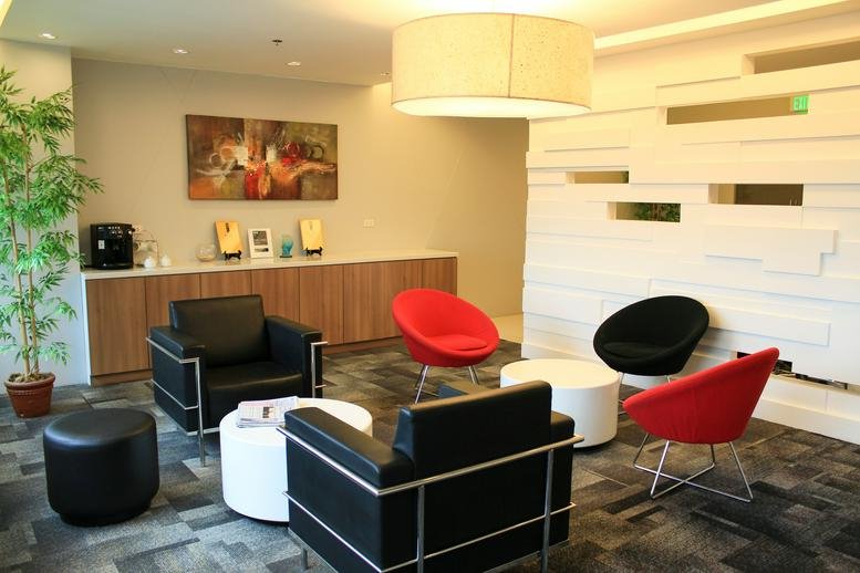 Spacious reception lounge at Sun Life Centre Building with red and black armchairs and a modern white partition wall.