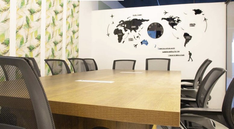 Spacious boardroom at Tahliah Street with a world map wall decal and wooden table.
