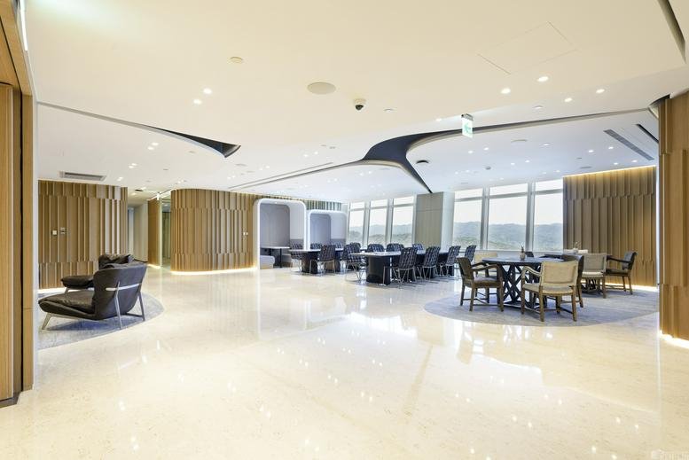 Spacious open-plan lobby with polished floors, modern seating, and large windows.