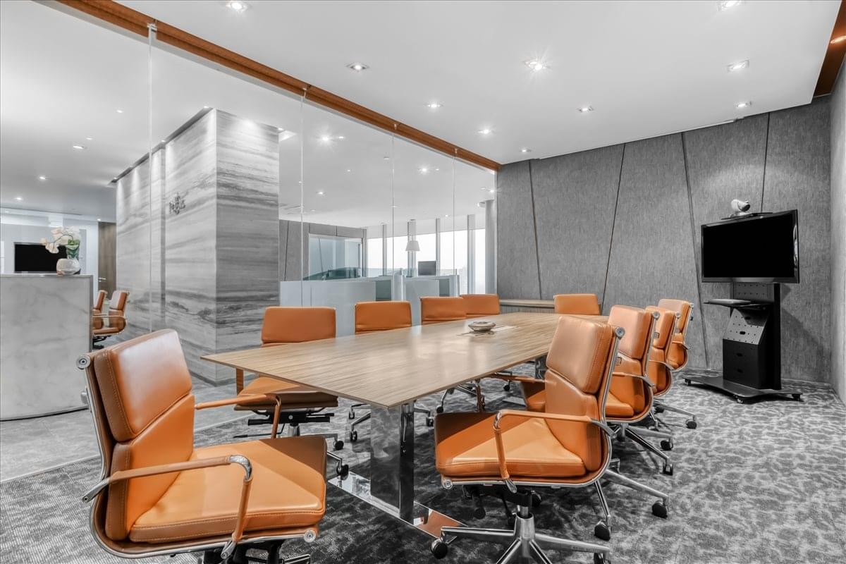 Spacious boardroom at Tempo Scan Tower featuring warm leather chairs and a long wooden table.