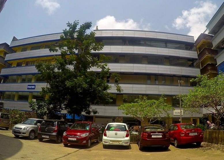 Exterior view of the multi-story Tex Centre building with a ground-floor parking area.