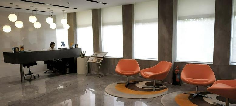 Spacious reception lobby at Thapar House, Delhi Gate no. 1 with orange armchairs and globe pendant lighting.