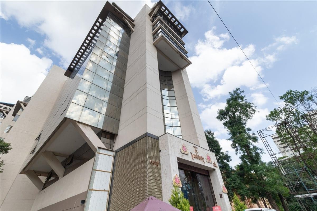 Exterior view of the multi-story The Estate, Dickenson Road building under a blue sky.