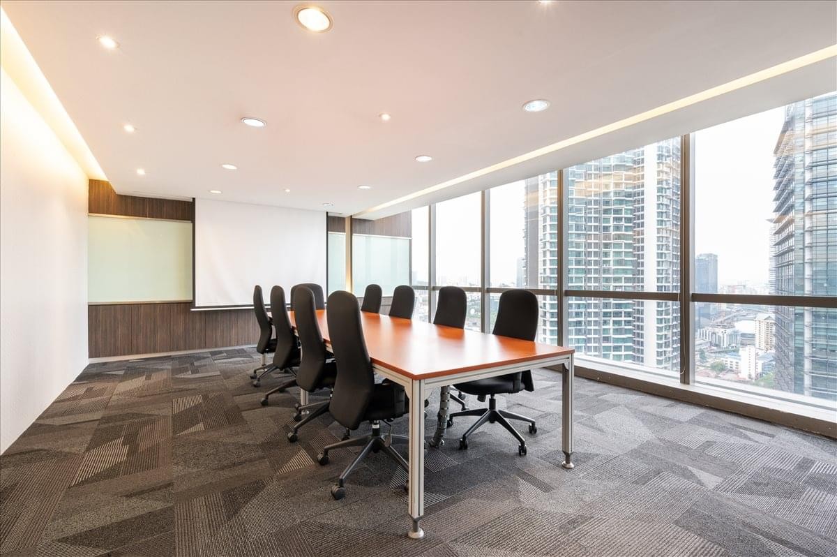 Spacious boardroom at The Gardens South Tower featuring floor-to-ceiling city views and a large timber table.