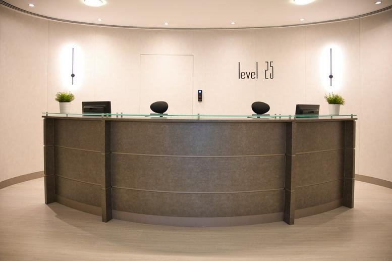 Wide view of the curved wood-paneled reception desk at The H Hotel Office Tower, Level 25.