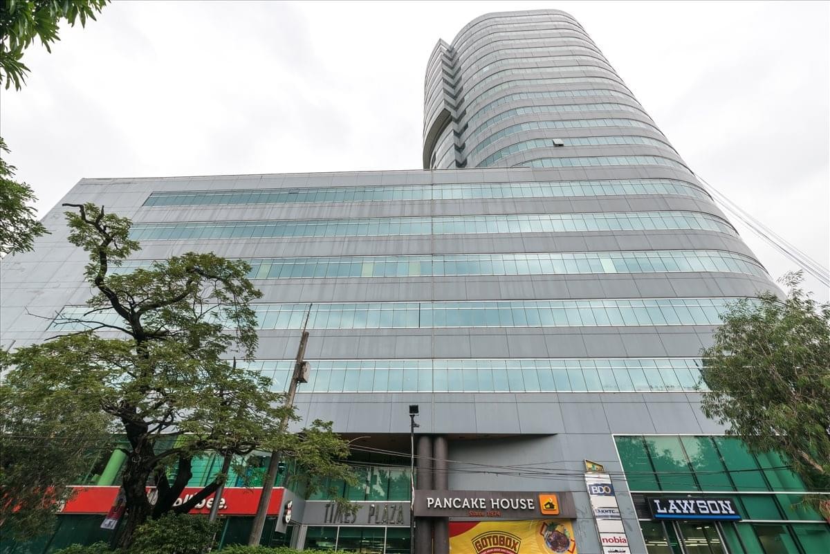 Low-angle exterior view of the modern glass-facade Times Plaza Building.