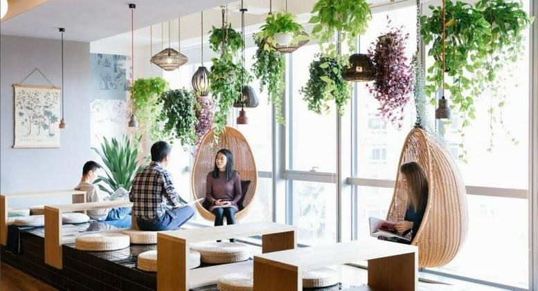 Bright breakout space with hanging plants and unique wooden pod chairs at Tokyo Square Garden, 14F, 3-1-1 Kyobashi.