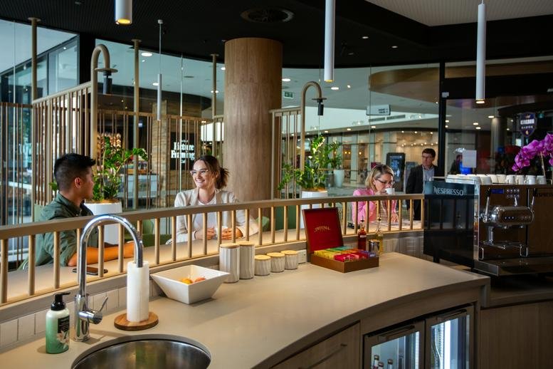 Spacious communal break area at Toowong Tower with a modern kitchen, wooden accents, and lounge seating.