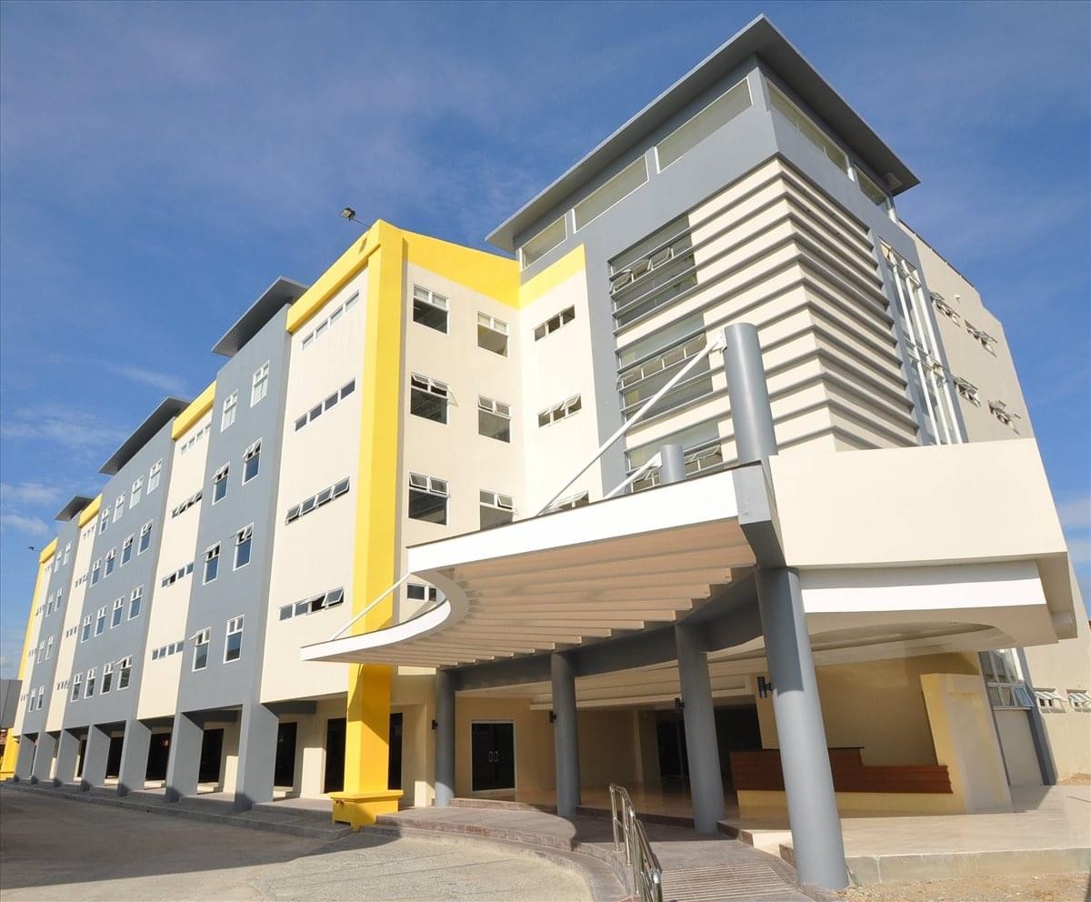 Exterior view of the modern Topaz Tower building with yellow accents and a large canopy.