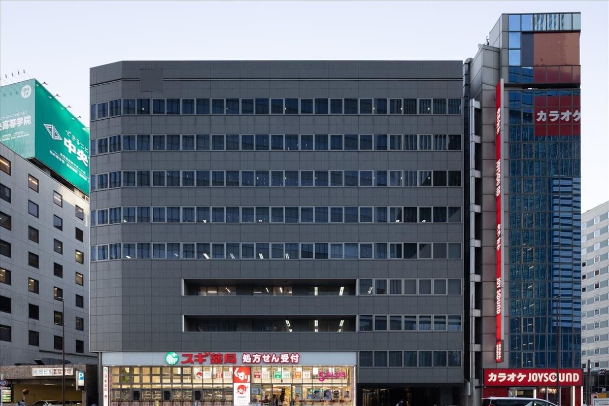 Exterior view of the dark grey facade of the 4F Toshin Meieki Building.