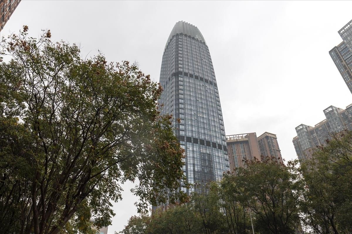 Exterior view of the skyscraper Tower 1, Yangyang Spring Investment Building with surrounding trees.