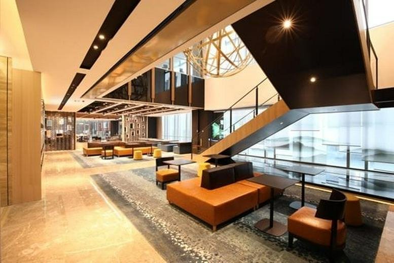 Spacious communal lounge at Tower B, Aerospace Science and Technology Square with modern seating and grand staircase.